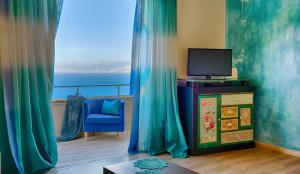 sala de estar con TV y silla azul en Villa Sophia, en Agios Nikolaos