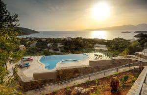 una vista de una piscina con el océano en el fondo en Villa Sophia, en Agios Nikolaos