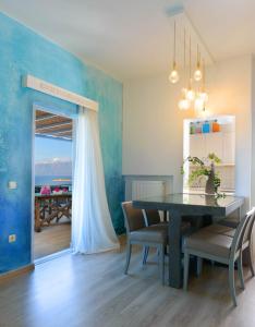 a dining room with a table and a blue wall at Villa Sophia in Agios Nikolaos