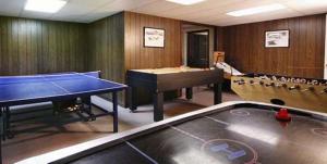 una stanza con tavolo da ping pong e palline da ping pong di Old Field House a North Conway