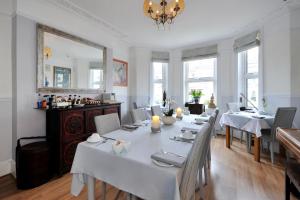 a dining room with a table and chairs and a mirror at Apple Tree boutique B&B in Bath