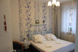 a bedroom with a bed with a blue floral wallpaper at Kolorowa Guest Rooms in Warsaw