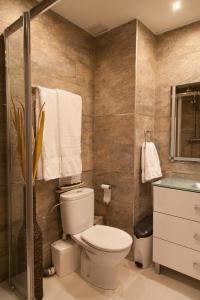 W łazience znajduje się toaleta i przeszklony prysznic. w obiekcie Apartamento City SOLO ADULTOS w Madrycie