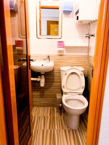 La petite salle de bains est pourvue de toilettes et d'un lavabo. dans l'établissement Holiday Guest House, à Hong Kong