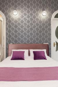 リヴィウにあるQueens Apartments 1のベッドルーム(紫色の枕が付くベッド付)