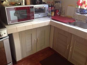 a kitchen counter with a microwave and a sink at Mariposas Rooms in Cancún