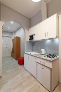 a kitchen with white cabinets and a stove top oven at Queens Apartments 1 in Lviv