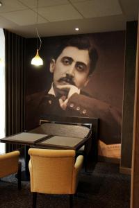 a painting of a man with a beard on a wall at Hotel Litteraire Le Swann, BW Premier Collection in Paris