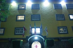un edificio con banderas y un reloj delante de él en Hotel Mina, en Ciudad de México