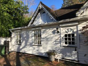 a white house with windows and a roof at Ford Cottage in Royal Tunbridge Wells