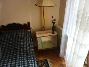 - une chambre avec un lit et une table avec un vase dans l'établissement Apartment Erekle, à Bordjomi
