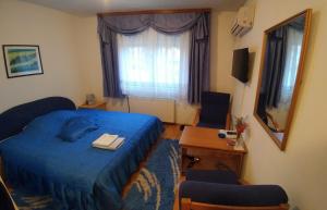 a bedroom with a blue bed and a window at Vila San in Banja Luka