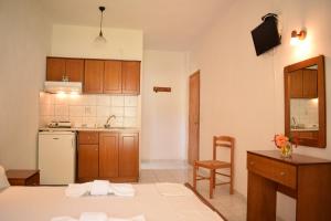 a kitchen with a table and a kitchen with a refrigerator at NIKIS ROOMS in Kalamakia