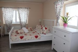 a bedroom with a white bed and a white dresser at Apartmany St. Maria in Staré Hory