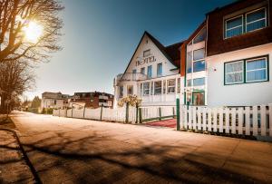 ein weißes Haus mit einem weißen Gartenzaun in der Unterkunft Hotel an der Linah garni in Buxtehude