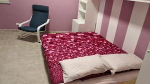 ein Schlafzimmer mit einem Bett und einem blauen Stuhl in der Unterkunft B&B Rossini in Augusta