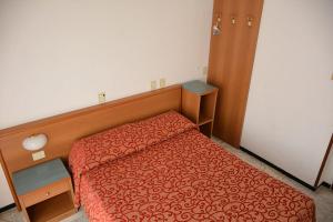 1 dormitorio con 1 cama con edredón rojo en Hotel Valentino, en Lavagna
