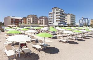 ein Haufen Stühle und Sonnenschirme an einem Strand in der Unterkunft Hotel San Francisco in Lido di Savio