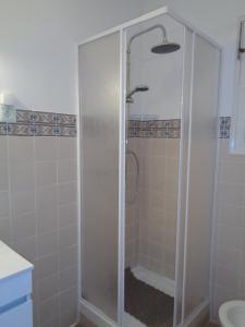 La salle de bains est pourvue d'une douche avec une porte en verre. dans l'établissement Apartamento do Barao, à Ponta Delgada