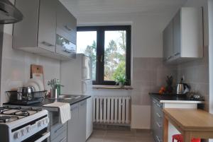 a kitchen with white cabinets and a stove top oven at Pokoje nad Starą Odrą - Zacisze in Wrocław