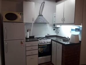 Duplex en Valle Hermoso في فالي هيرموسو: مطبخ صغير مع موقد وثلاجة +8 صور