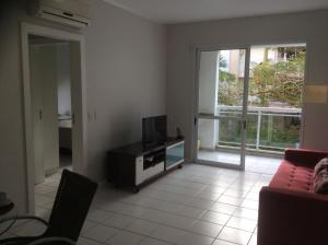 sala de estar con sofá y TV en Bem localizado com sacada, churrasqueira, garagem e split, en Florianópolis