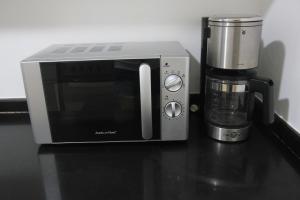 a microwave sitting on a counter next to a coffee maker at Marquee Residences in Angeles