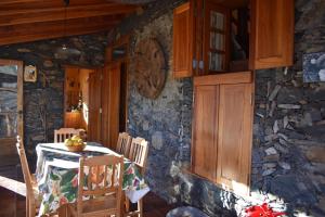 a kitchen with a table and a stone wall at Casa Rural Finca la Maleza in Agulo