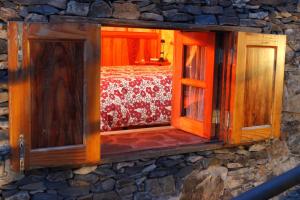 a window in a stone building with a bed at Casa Rural Finca la Maleza in Agulo