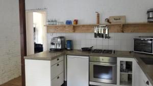 eine Küche mit weißen Schränken und einer Arbeitsplatte in der Unterkunft Riley's cottage in Hemrik