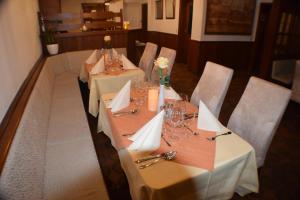 a set of tables in a restaurant with white table cloth at Hotel Bürgergesellschaft in Betzdorf
