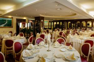 una sala banchetti con tavoli e sedie con tovaglie bianche di Grand Hotel Osman & Spa e Ristorante il Danubio a Atena Lucana