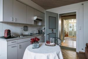 a kitchen with a table in the middle of it at Art Deco Villa Mon Abri BnB in Goldau