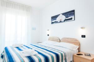 1 dormitorio con 1 cama con 2 toallas en Residence Cigno en Rímini