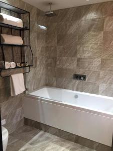 a bathroom with a white tub and a toilet at Charter House in Newport