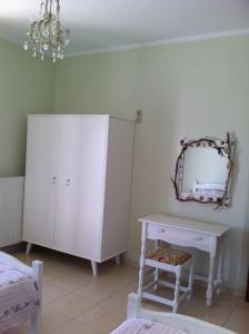 a bedroom with a dresser and a mirror at Eleni Apartments in Arillas