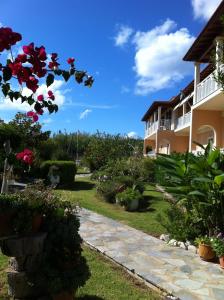 a garden in front of a building with flowers at Eleni Apartments in Arillas