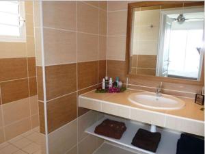 een badkamer met een wastafel en een spiegel bij Ti ' Plage in Les Trois-Îlets