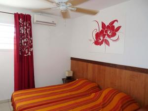 sypialnia z łóżkiem i wentylatorem sufitowym w obiekcie Ti ' Plage w mieście Les Trois-Îlets