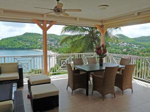 a balcony with a table and chairs and a view of the ocean at Ti ' Plage in Les Trois-Îlets