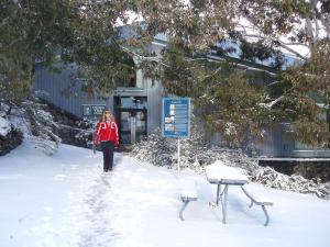 a woman standing in front of a snow covered ski slope at Thredbo YHA in Thredbo