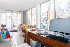 a computer monitor on a desk in a room with windows at Residence Cigno in Rimini
