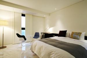 1 dormitorio con cama, escritorio y silla en Urban Boutique Hotel, en Anyang