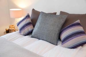 Beautiful one Bedroom apartment walking distance to Paddington and Hyde Park في لندن: سرير عليه ثلاث مخدات