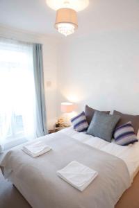 ein Schlafzimmer mit einem großen Bett mit Kissen und einem Fenster in der Unterkunft Beautiful one Bedroom apartment walking distance to Paddington and Hyde Park in London