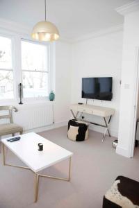 ein Wohnzimmer mit einem TV und einem Couchtisch in der Unterkunft Beautiful one Bedroom apartment walking distance to Paddington and Hyde Park in London