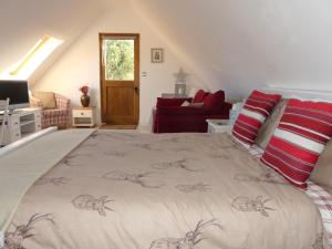 a bedroom with a large bed in a attic at Lacewing Lodge in Sharnbrook