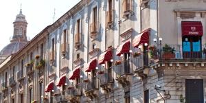 un edificio con balcones rojos y una torre de reloj en B&B Stesicoro InHabit, en Catania 27 fotos más