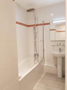 a white bathroom with a shower and a sink at Le Napoleon in Lille