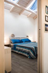 um quarto com uma cama com almofadas azuis em Mediterranean house em SantʼAntìoco